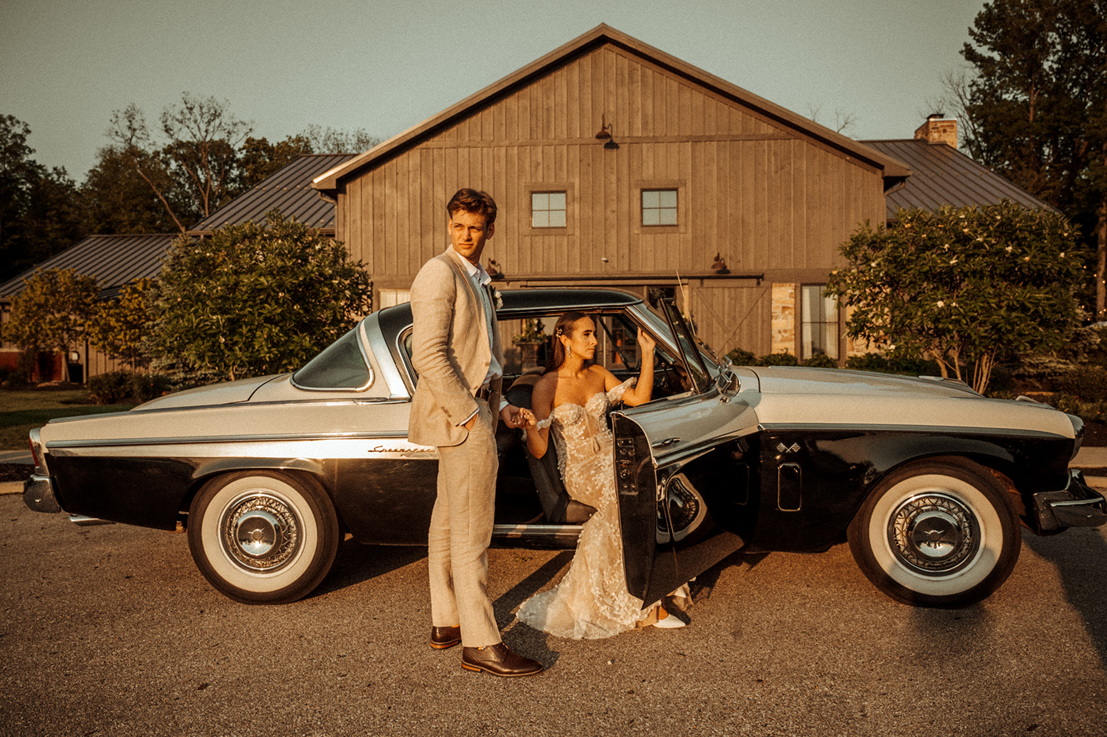 Bride and groom sitting in a vintage car for barn wedding in Indiana